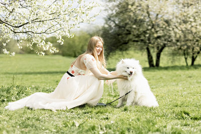 Side view of woman with dog on field