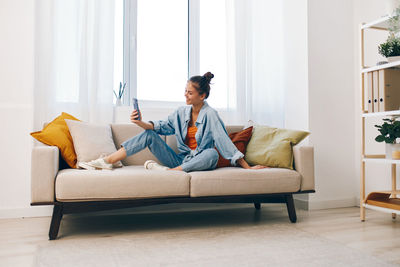 Portrait of young woman sitting on sofa at home