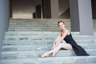 Portrait of woman sitting on staircase