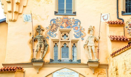 Low angle view of statues on wall of building