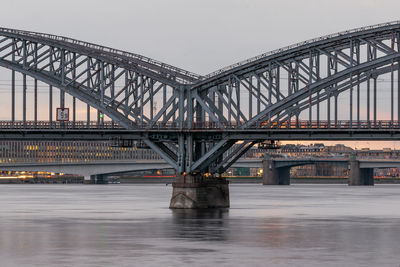 Bridge over river against sky during sunset