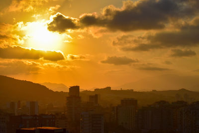 Silhouette buildings against sky during sunset
