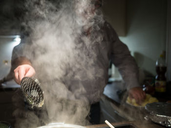 Midsection of man preparing food in kitchen