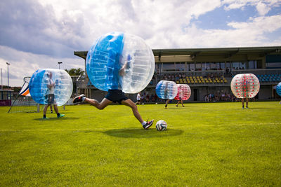 Men playing soccer with zorb balls on field