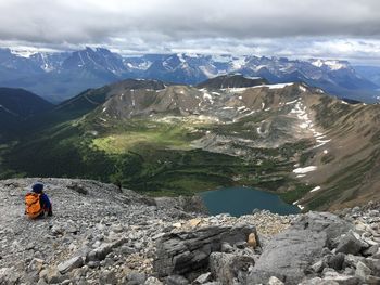 Rear view of hiker on mountain against sky