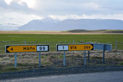 Information sign on road against sky