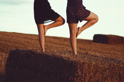 Low section of women exercising on landscape