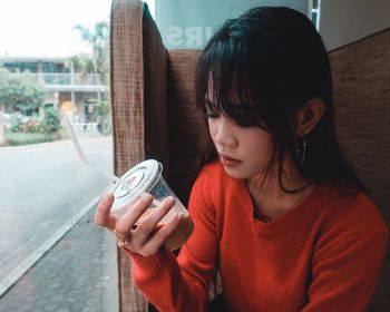 Girl looking away while holding window