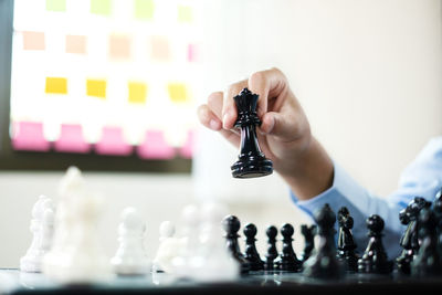 Cropped hand of woman holding chess pieces