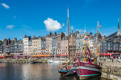 Sailboats in canal against buildings in city