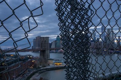 View of city seen through chainlink fence