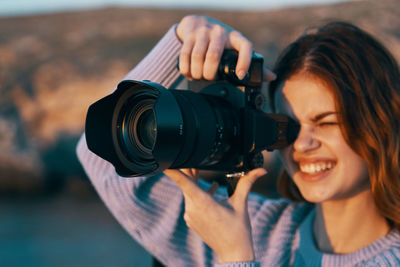 Portrait of smiling woman holding camera