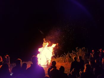 Group of people by campfire at night