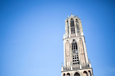 Low angle view of bell tower against clear blue sky