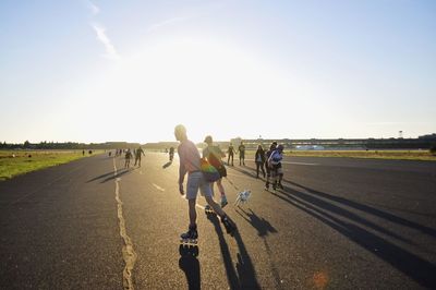 Rear view of people playing on road