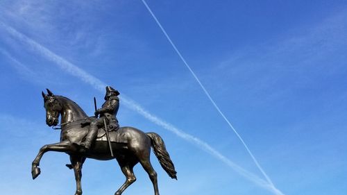 Low angle view of statue against blue sky