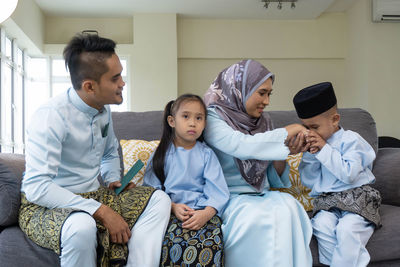 Full length of father and daughter sitting on floor