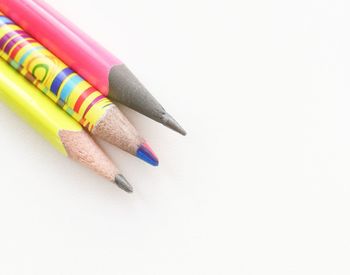 High angle view of colored pencils against white background