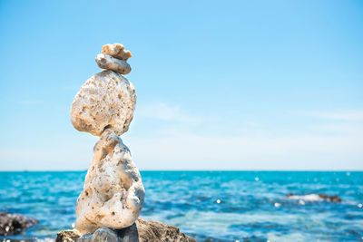 Zen stones balance at stony beach and sea background