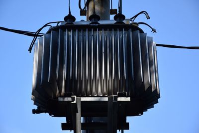 Low angle view of metal structure against blue sky