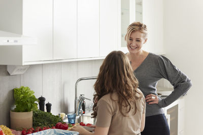 Mother and daughter standing in kitchen