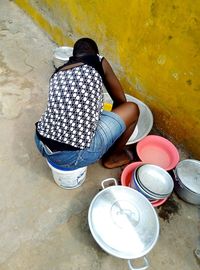 Rear view of woman sitting against wall