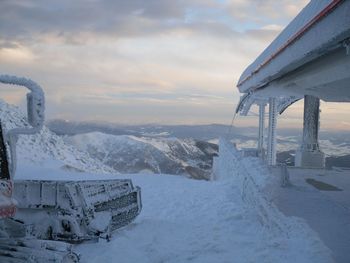 Scenic view of snow covered mountains against sky during sunset