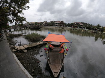Scenic view of river against sky during rainy season, traditional vietnamese vessel boat 