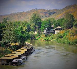 Scenic view of lake by buildings against sky