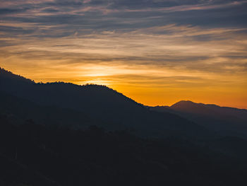 Scenic view of silhouette mountains against sky during sunset