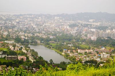River amidst cityscape against sky