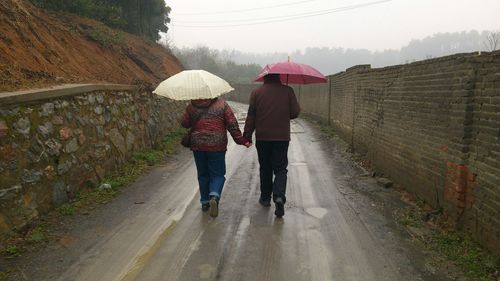 Rear view of couple walking on road