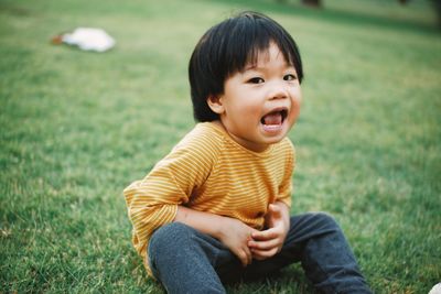 Portrait of boy sitting on field