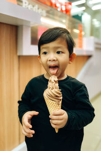 A boy is holding an ice cream and enjoying it