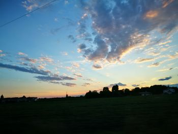 Scenic view of silhouette field against sky at sunset