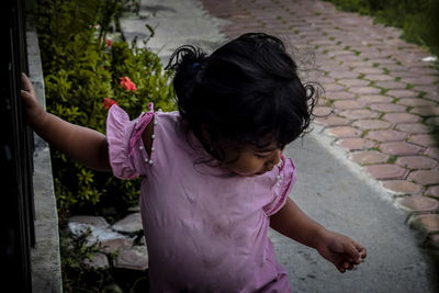 Rear view of woman standing on footpath