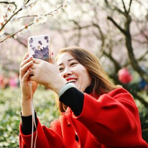 Portrait of young woman using smart phone in winter