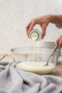 Close-up of hand pouring coffee cup on table
