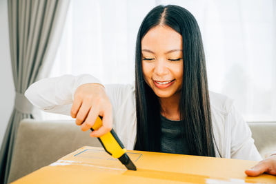 Portrait of smiling young woman using digital tablet at home