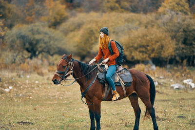 Horse riding horses on a field