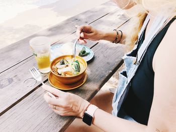 High angle view of hand holding drink on table