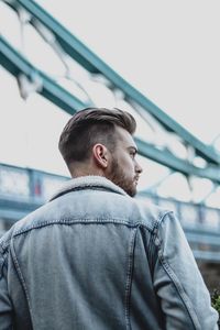 Rear view of man looking at camera