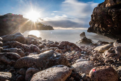 Rocks on beach against sky