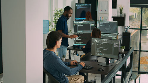 Rear view of man using laptop at home