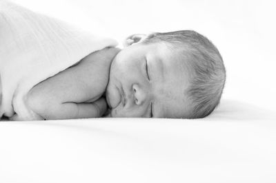 Close-up of baby sleeping on bed