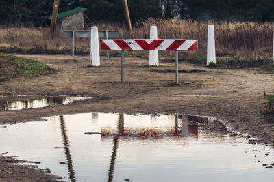 Lifeguard hut on field by lake