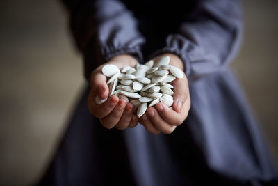 Midsection of woman holding pills