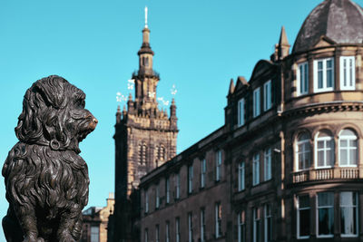 Low angle view of statue against buildings in city