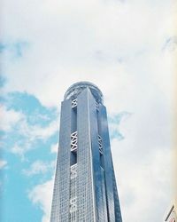 Low angle view of modern buildings against cloudy sky