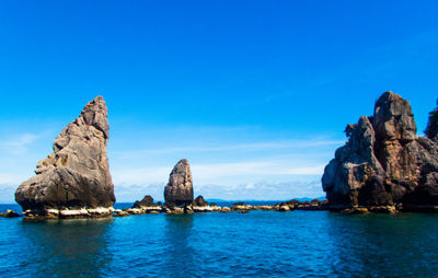 Panoramic view of sea and rock formations against blue sky